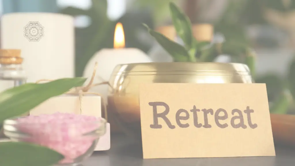 נרות דולקים ושלט עץ עם הכיתוב Retreat - ריטריטים של סטודיו גלית יוגה